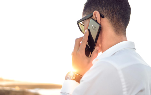 A man holds a smartphone up to his ear