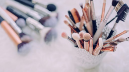 Makeup brushes in a container and lying on their side
