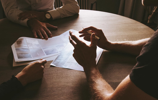 People discussing something over pieces of paper