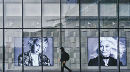 Person walks in front of a building with pictures