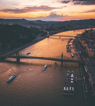 Bridge over sunset river in urban environment