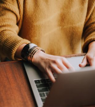 A woman types on a laptop