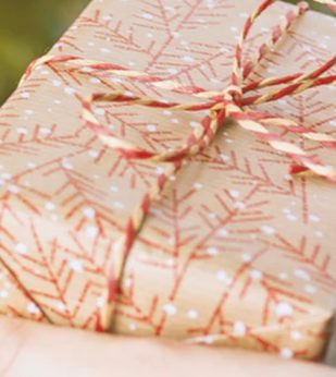 Woman holds a wrapped Holiday gift in her hands