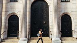 A woman walks in front of a bank